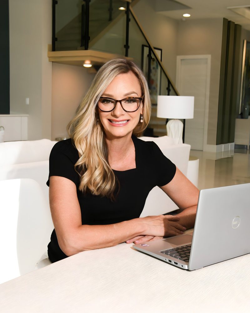 Jennifer Gannon smiling at a table with her laptop